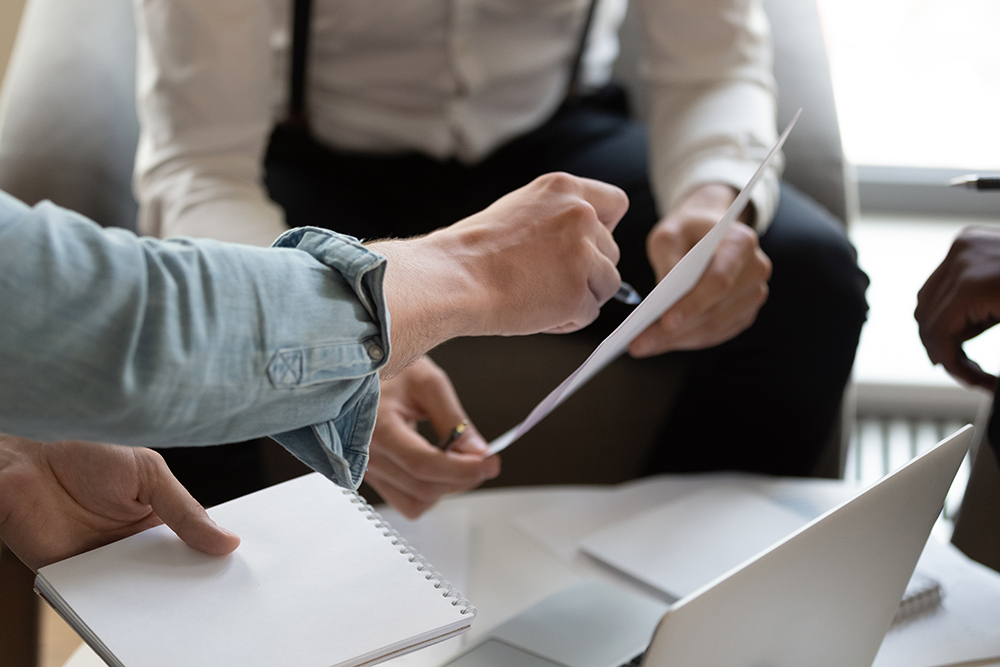 Close up cropped view unrecognizable businesspeople do paperwork during meeting in office, bank worker explain contracts terms conditions to client, discuss credit application, financial deal concept