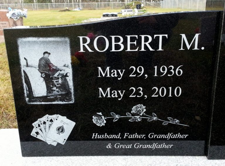 Black granite monument, Robert M. A card poker hand as well as a photo of Robert on his tractor is etched onto the stone.