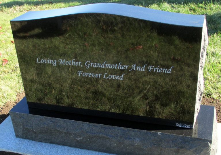 The back side of a black monument that reads Loving mother, grandmother and friend forever loved.
