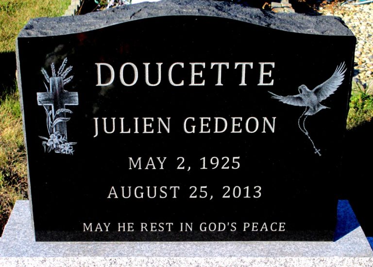 Black granite monument. The left side has a cross with wheat surrounding it. The right side has a dove soaring through the air with a cross necklace in it's mouth. The name on the headstone reads Doucette Julien Gedeon. May 2, 1925-August 25, 2013. The bottom has a quote that reads May He Rest In God's Peace.