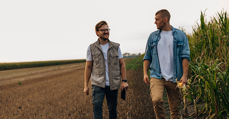 Front view of two agronomists walking in the fields.