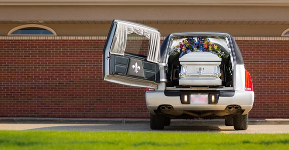 Hearse with casket and flowers in front of Oliver's Funeral Home Grande Prairie Alberta